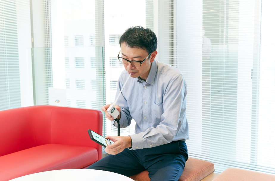 アルコール検知器を使っている様子。アルコールチェックデータを含む運行記録は全てスマートフォンアプリなどを経由しクラウドに保存できる